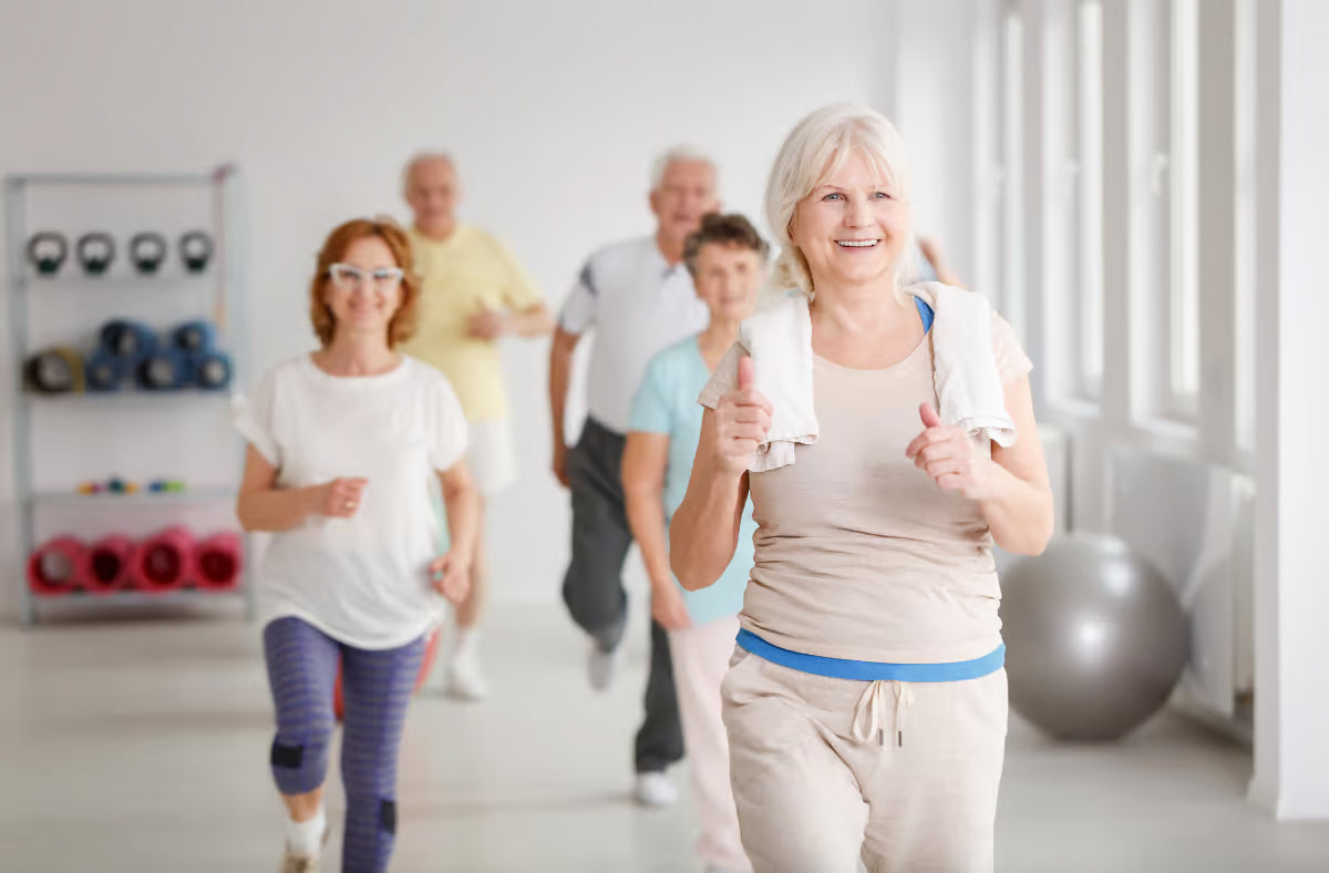 Group of smiling seniors exercising together in a bright fitness studio