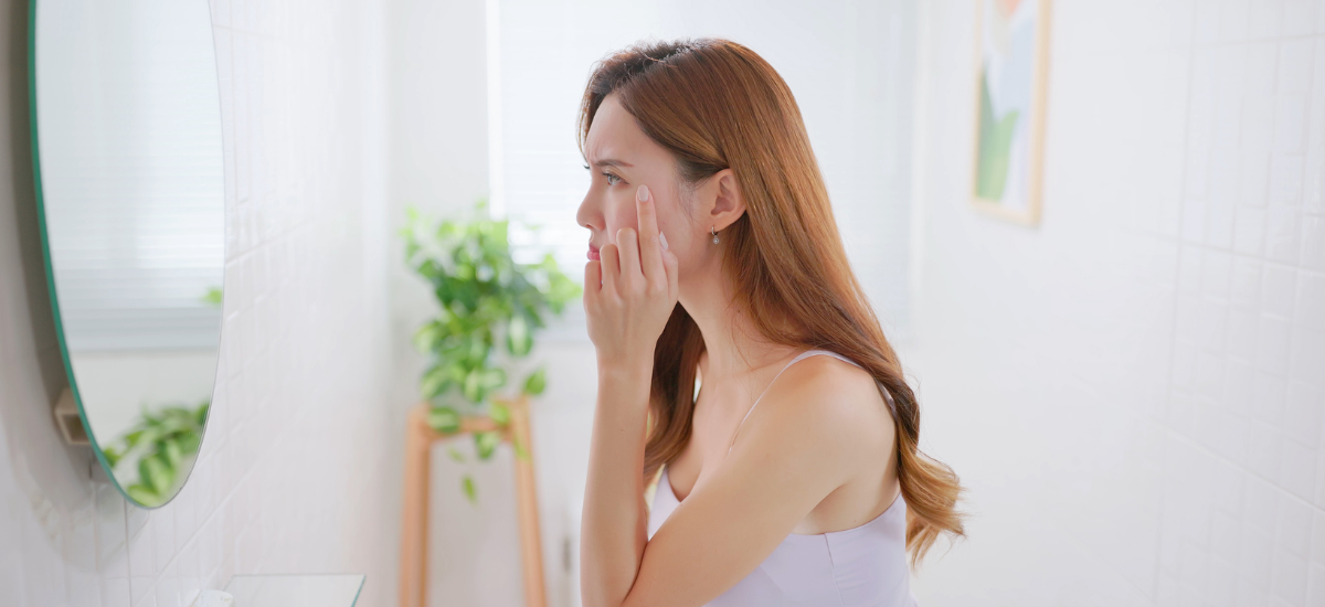A woman looking in the mirror and checking the state of her wrinkles