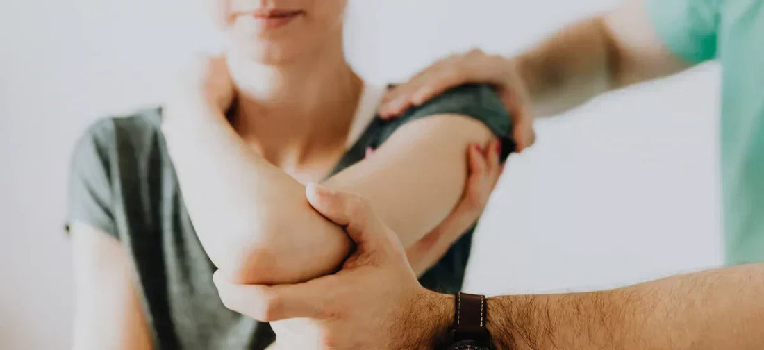 The doctor examines the woman's bent elbow and joints
