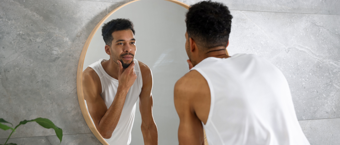 Man looking in the mirror to check the effects of using liquid collagen