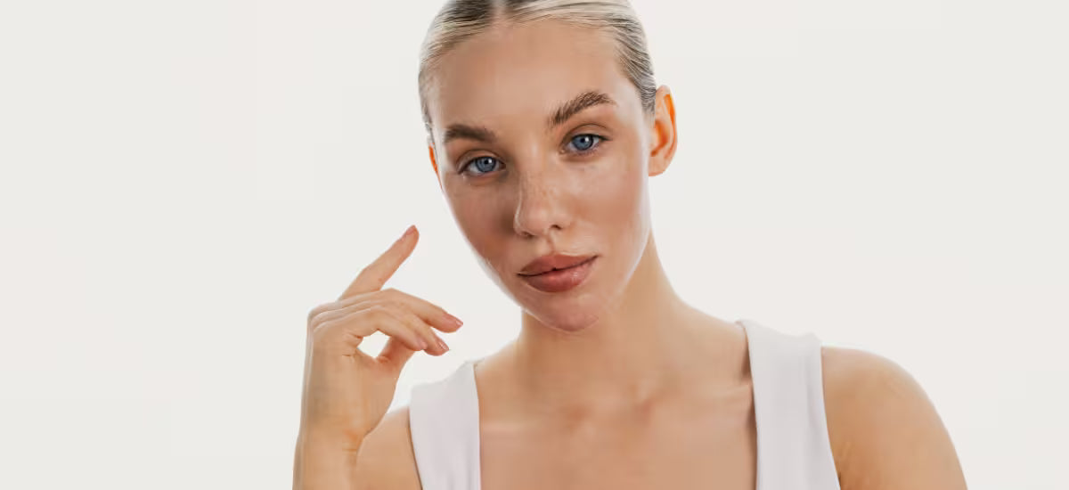 Young woman with clear, healthy-looking skin gently touching her face