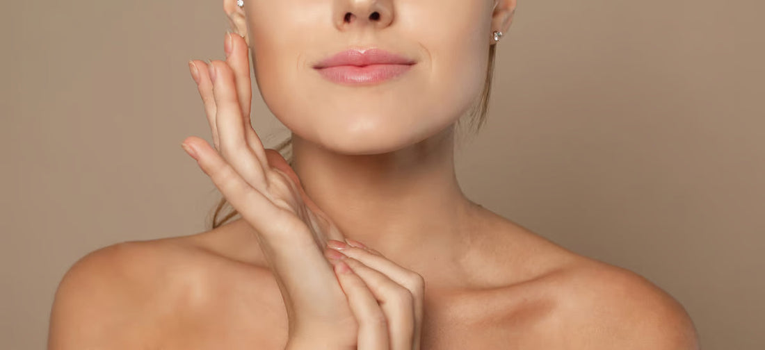 Young woman with smooth, glowing skin gently touching her face after using Primabiotic Collagen.