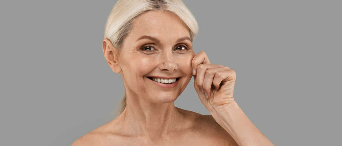 Smiling mature woman touching her cheek, showing effects of Primabiotic collagen supplementation for sagging skin