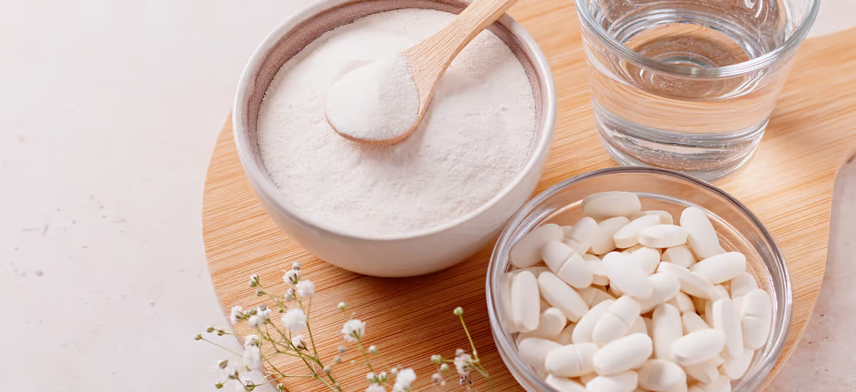 collagen powder and tablets placed in bowls on a wooden board