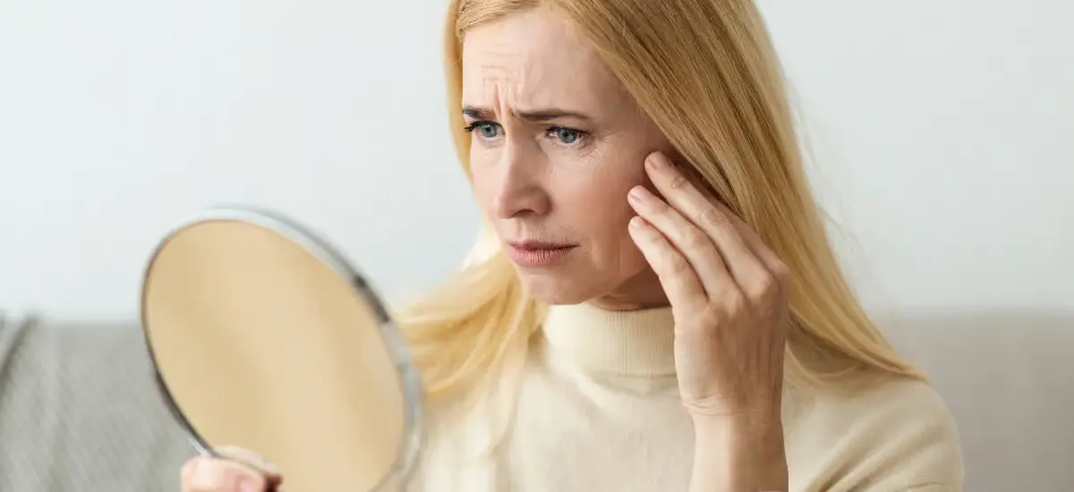 Older woman looking at her face in the mirror